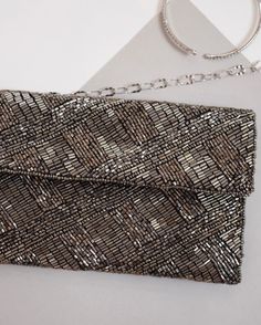 Fully Beaded Bag with a beautiful criss cross pattern. This clutch includes a metal chain strap. Dimensions: 9″ x 4.5″ (22.9 x 11.4 cm) Rectangular Silver Evening Bag, Silver Embellished Shoulder Bag, Silver Beaded Clutch Shoulder Bag, Silver Beaded Shoulder Bag Clutch, Silver Crossbody Clutch With Chain Strap, Chic Silver Beaded Bag, Luxury Silver Beaded Bag, Silver Crossbody Clutch For Evening, Luxury Silver Beaded Evening Bag