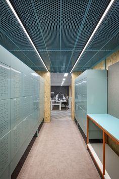 a long hallway with several lockers and tables on each side in an office building