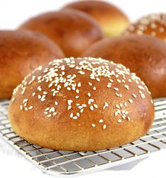 buns with sesame seeds sit on a cooling rack