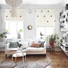 a living room filled with furniture and lots of plants on top of it's shelves