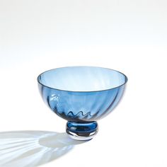 a blue glass bowl sitting on top of a white table