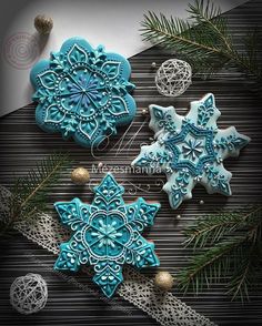 three snowflake cookies sitting on top of a table