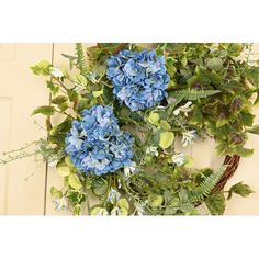 a wreath with blue flowers and green leaves