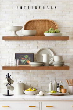 the shelves in this kitchen have plates and bowls on them