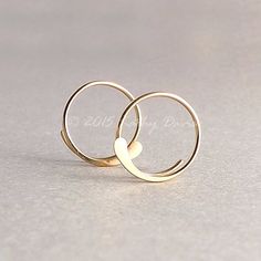 These open hoops are handmade by me from shiny 20 gauge 14k gold filled wire. They've been cold forged on one end to highlight the curve; then sanded smooth for comfort in wearing and to give them a satiny shine. Photos show the small 1/2 inch size (14mm in diameter).. 3/4 inch size is 20mm in diameter 1 inch size is 26mm in diameter. This popular style is built as a coil. There is no need to pull apart to put on, simply slide the thin part in your ear and move until the hammered tab is at the b Open Hoop Earrings, Gold Filled Hoops, Hoop Earrings Gold, Womens Jewelry, Eco Friendly Jewelry, Wire Earrings, Gold Hoops, Rose Gold Earrings, Gold Filled Jewelry