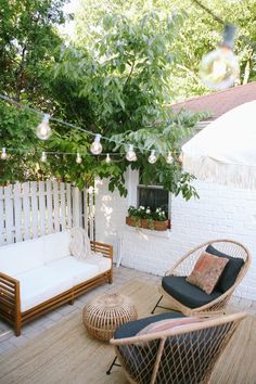 an outdoor patio with wicker furniture and hanging lights