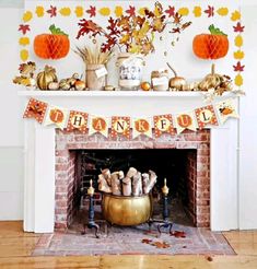 a fireplace decorated with fall decorations and paper pumpkins