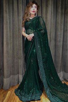 Dazzle everyone around as you walk into a wedding wearing this dark green georgette saree which will provide you with unmatched all day comfort.This sweetheart neckline and sleeveless blouse is perfectly formed using resham thread and sequins work.It is set together with a georgette heavy work saree in dark green color beautified with sequins, resham thread, and lace work.This saree blouse can be customized up to the maximum size available in inches 58 around the bust. Slight color variation may occur due to photographic reasons. Sangeet Saree, Heavy Work Saree, Green Georgette Saree, Heavy Work, Dark Green Color, Green Sequins, Work Sarees, Georgette Fabric, Party Wear Sarees