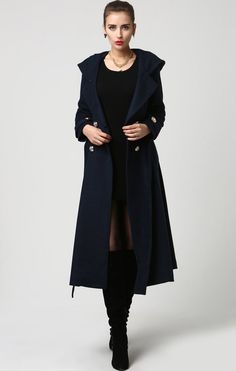 "This beautiful long wool coat features a double-breasted bodice and oversized silver buttons to create a distinct but classic military style. this winter coat features gorgeous navy blue wool, a polyester lining, and fun features like extra long sleeves, deep side pockets and back split vents. The self-tie belt makes it easy to accentuate your waist while the warm hood will stylishly shield you from the cold. DETAIL * 50% WOOL,50% POLYESTER * POLYESTER LINING * Epaulette with button * with warm Double-breasted Peacoat For Office In Winter, Double-breasted Winter Office Peacoat, Winter Office Peacoat With Buttons, Blue Double-breasted Elegant Peacoat, Elegant Double-breasted Blue Peacoat, Blue Double-breasted Peacoat For Winter, Blue Double-breasted Wool Coat With Button Closure, Spring Long Peacoat With Buttons, Spring Peacoat With Buttons