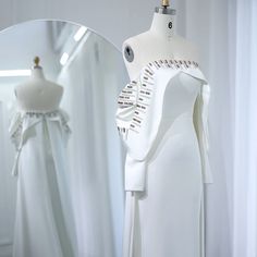 a white dress on display in front of a mirror