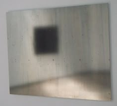 a white wall with a black square on it