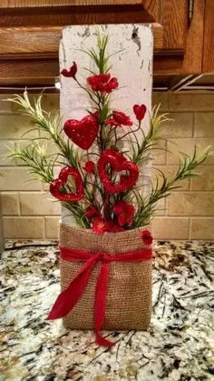 red flowers in a burlock wrapped gift on a kitchen counter with brown cabinets