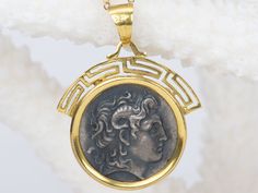 ♥ A solid 14K yellow gold pendant encasing a sterling silver Alexander the Great coin (a replica of a real ancient coin) ♥ The pendant measures 23.8 mm in length, 22.3 mm in width, and 2.2 mm thick. ♥ Material: 14K Yellow Gold ♥ The necklace chain is *NOT INCLUDED*. You can purchase the solid 14K gold chain as an option, or use one of your existing chains for the pendant. ♥ Free shipping in the US. ♥ This is an in-stock item and ready to ship right away! ▶▶ Sign up for our newsletter to receive a 10% off coupon for purchases from our website: https://www.auroradesigner.com/pages/newsletter-sign-up Luxury Coin-shaped Intaglio Jewelry, Luxury Engraved Coin Necklace, Ancient Yellow Gold Jewelry For Collectors, Ancient Style Collectible Yellow Gold Jewelry, Collectible Ancient Style Yellow Gold Jewelry, Ancient Style Medallion Coin Pendant Jewelry, Ancient Yellow Gold Coin Pendant Jewelry, Ancient Engraved Round Coin Necklace, Engraved Ancient Coin Necklace