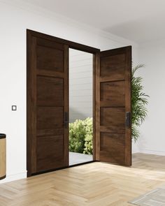 an empty room with two wooden doors and a potted plant on the floor next to it