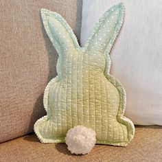 a stuffed animal sitting on top of a couch next to pillows and pillow cases with white dots