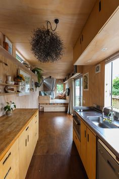 a kitchen with wooden cabinets and counters next to a living room on the other side