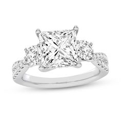 a princess cut engagement ring with three stones on the band and an accent diamond in the center