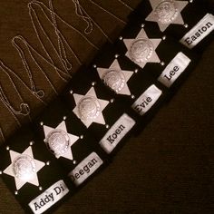 several police badges and name tags are displayed on a black tie that says, bobby dean