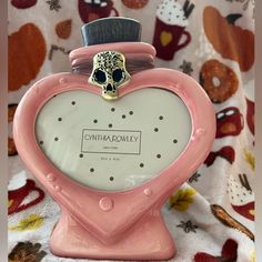 a pink heart shaped clock with a skull on top