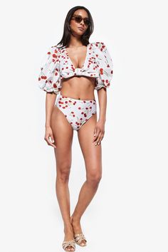 This item is final sale. Iconic and irreverent, AD's swimwear pieces are versatile and dynamic to be worn between the beach and the city. This Cherry Bomb print swimsuit can be worn with a pareo skirt for lunch by the pool. Combine with the skirt of the same print and low-heeled sandals and you will have a new look for evening drinks! Model is wearing a size small This item runs true to size Composition85% POLYAMIDE 15% SPANDEX White Printed Swimwear For Resort Season, Chic Printed Swimwear For Vacation, Chic Printed Swimwear For Pool, Trendy Summer Swimwear For Brunch, Chic Short Sleeve Swimwear For Pool, Chic Short Sleeve Swimwear For Beach, Chic Printed Swimwear For Poolside, Trendy Short Sleeve Swimwear For Spring, Trendy Short Sleeve Swimwear For The Beach