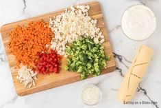 chopped up vegetables on a cutting board next to dip