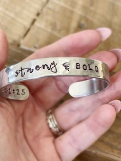 Introducing the Uplift Collection featuring hand stamped metal cuff bracelets with encouraging reminders of who you and whose you and scripture reference. Choose one bracelet: 1. STRONG & BOLD 3/8" CUFF 2. BEAUTIFUL WARRIOR 1/2" CUFF 3. GRACIOUS & KIND 1/4" CUFF 4. MADE WORTHY 1/2" CUFF 5. VICTORIOUS 3/8" CUFF 6. CHOSEN & KNOWN 1/4" CUFF Each bracelet has a scripture reference written on the inside of the cuff. Add a leather wrap bracelet here: https://etsy.me/3koMuWo Add a Rhinestone Bracelet h Beautiful Warrior, Stamp Jewelry, Hand Stamped Cuff Bracelet, Warrior 1, Rhinestone Bra, Hand Stamped Metal, Stamped Spoons, Metal Stamped Jewelry, Metal Cuff Bracelet