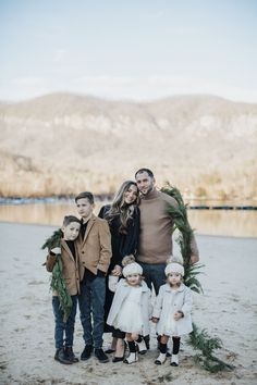 a family posing for a photo in front of the water with their christmas wreaths