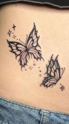 a woman's stomach with two black butterflies on the side and stars in the back