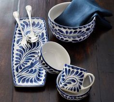 a wooden table topped with blue and white dishes