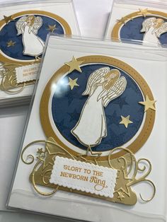 three cards with gold and blue designs on them, one is for the new born baby