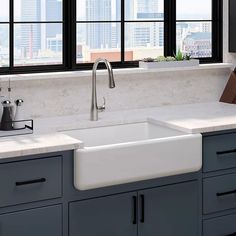 a white kitchen sink sitting under a window next to a counter top with utensils