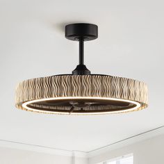 a circular light fixture hanging from the ceiling in a room with white walls and windows