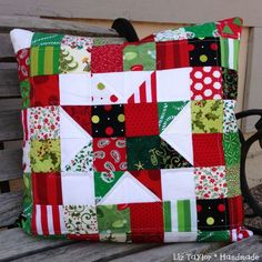 a patchwork pillow sitting on top of a wooden bench