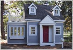 a small gray and white house with red door