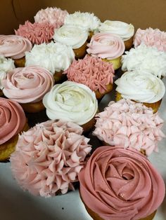 cupcakes with pink and white frosting are arranged in a circle on a table