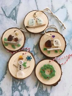 four wood slices with ornaments on them sitting on a table