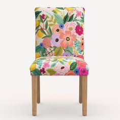 an upholstered chair with colorful flowers and leaves on the back, against a white background