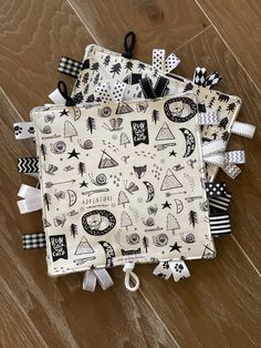 several pieces of cloth with black and white designs on them sitting on a wooden floor