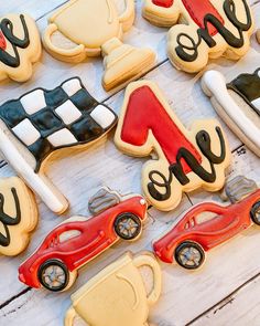 decorated cookies with racing cars and race flags on top of a white wooden table next to each other