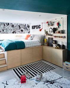 a bed room with a neatly made bed and lots of drawers on the wall next to it