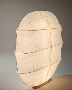 a large white lamp sitting on top of a wooden stand