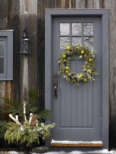 a gray front door with a wreath on it