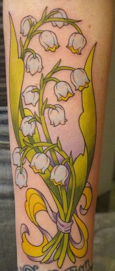 a tattoo with lily of the valley flowers on it's leg and words written in cursive writing