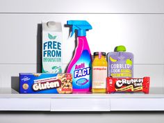 various household cleaning products are displayed on a white shelf, including detergent and dishwasher