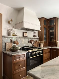 a stove top oven sitting inside of a kitchen next to wooden cabinets and counter tops