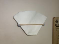 a white napkin hanging on the wall next to a ruler