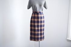 "Description: A navy and brown plaid pencil skirt with back metal zipper and snaps for closure. Unlined. Measurements of garment, allow space for fit. Waist: 25.5\" Hips: 38\" Length: 28\" I take my measurements flat, and double for circumference. Tag: No tag, looks handmade. Fabric: Wool or blend Condition: Excellent Follow along on instagram @lovecharlesvintage" Fitted Plaid Skirt For Office, Fitted Plaid Pencil Skirt, Fitted Plaid Pencil Skirt For Work, Bonnie Cashin, Plaid Pencil Skirt, Grand Rapids Mi, Navy And Brown, Brown Plaid, Handmade Fabric