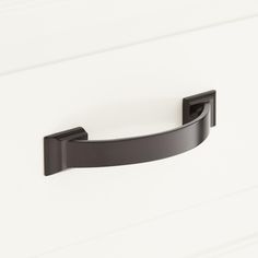 a black handle on a white cabinet door