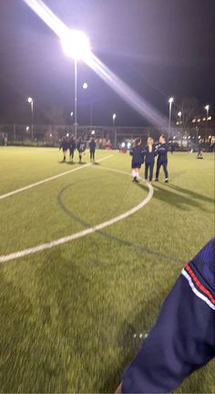 a group of people standing on top of a soccer field