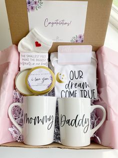 two coffee mugs in a box with congratulations written on them